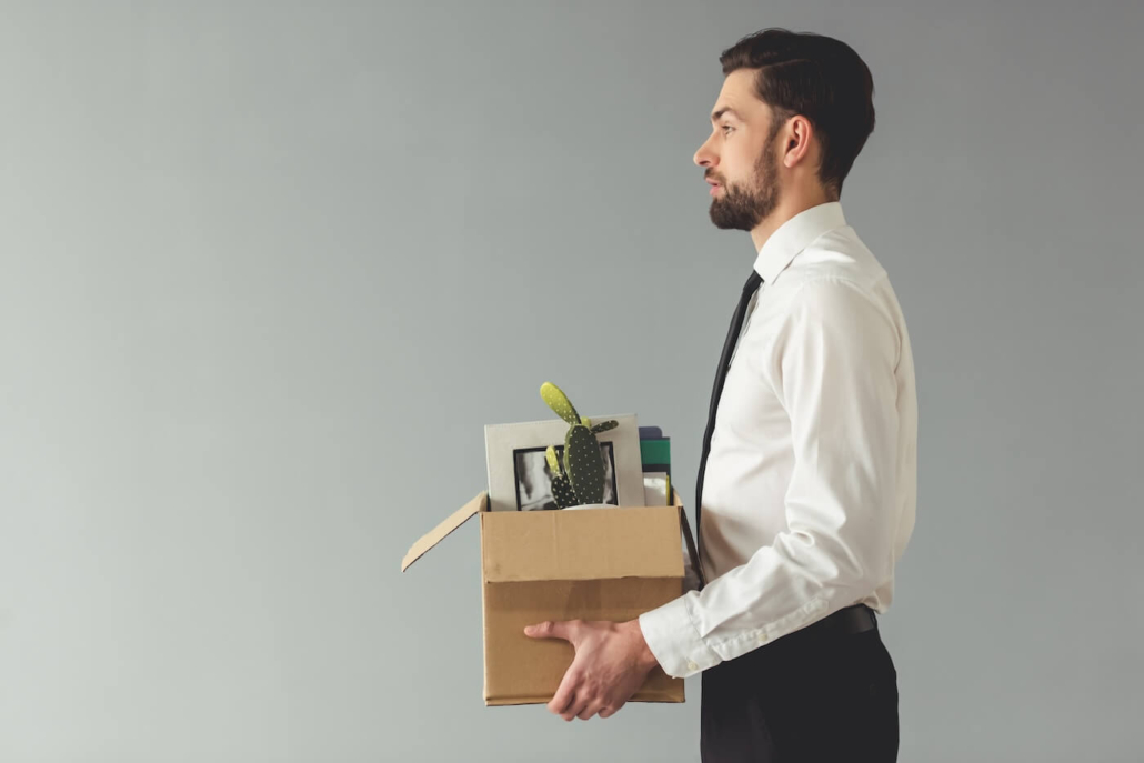 Businessman in formalwear holding a box with his belongings