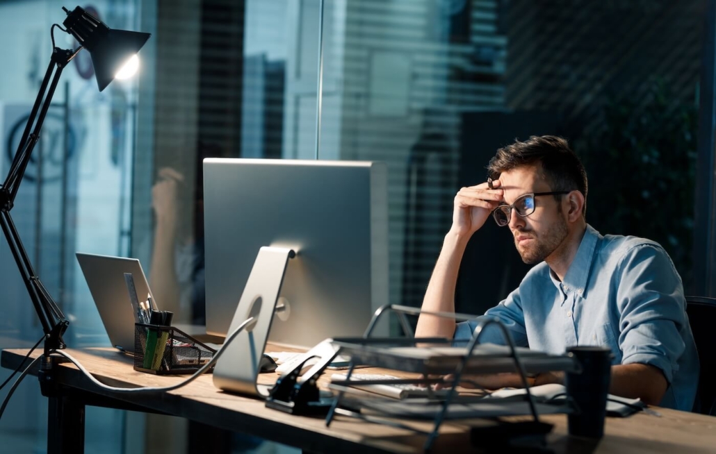 Tired casual office worker sitting at desk